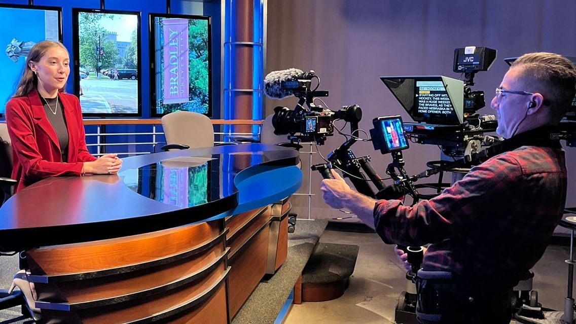 Delaney reads a teleprompter while a College Tour videographer captures her image